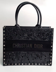 Dior сумка в чёрной коже, с узорами и клёпками.